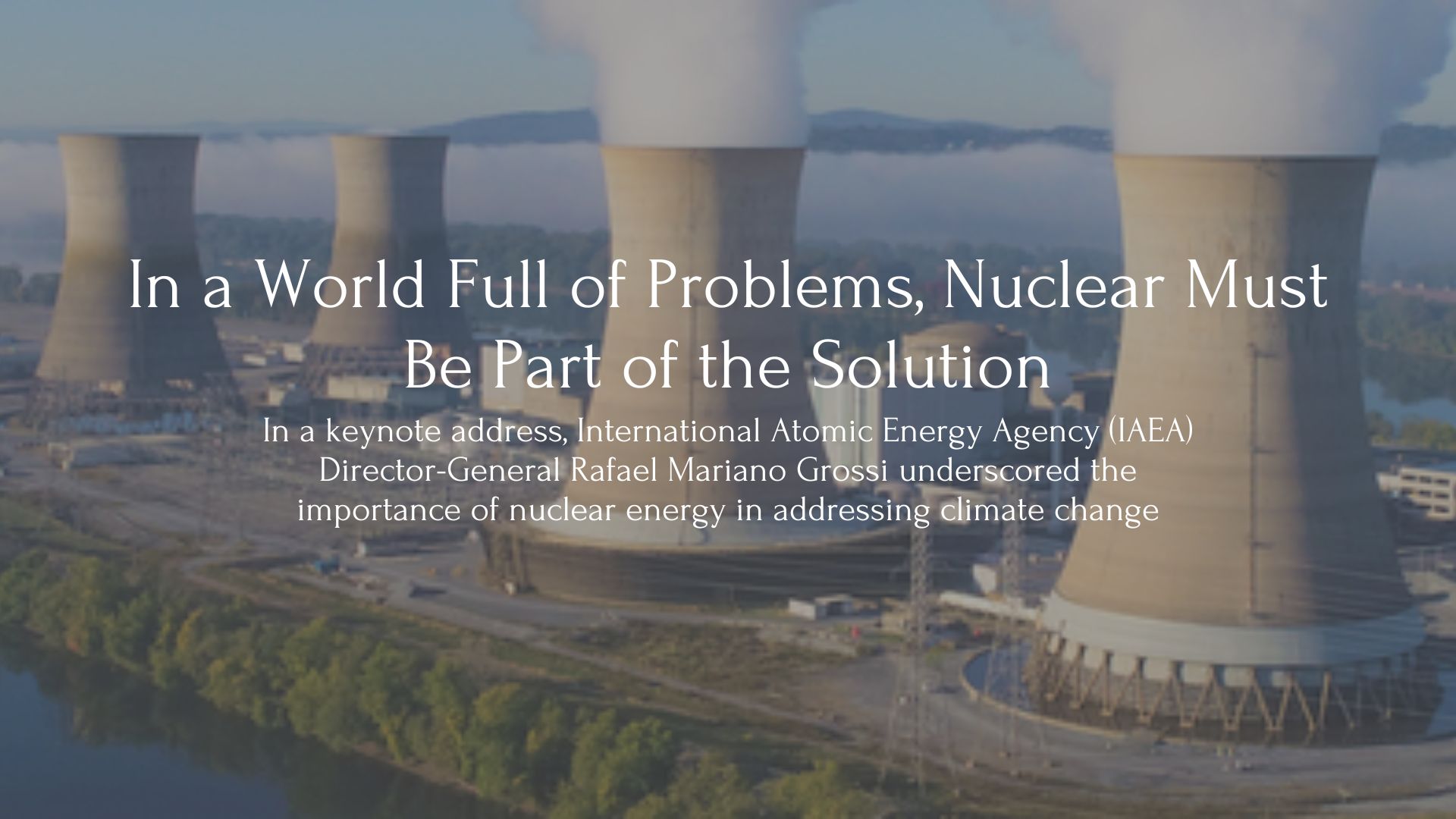 Text: In a World Full of Problems, Nuclear Must Be Part of the Solution. In a keynote address, International Atomic Energy Agency (IAEA) Director-General Rafael Mariano Grossi underscored the importance of nuclear energy in addressing climate change. Behind the text sits an image of 4 nuclear reactors
