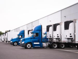 a row of trucks parked in front of a warehouse