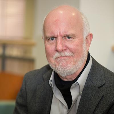 a man with a beard in a grey sport coat