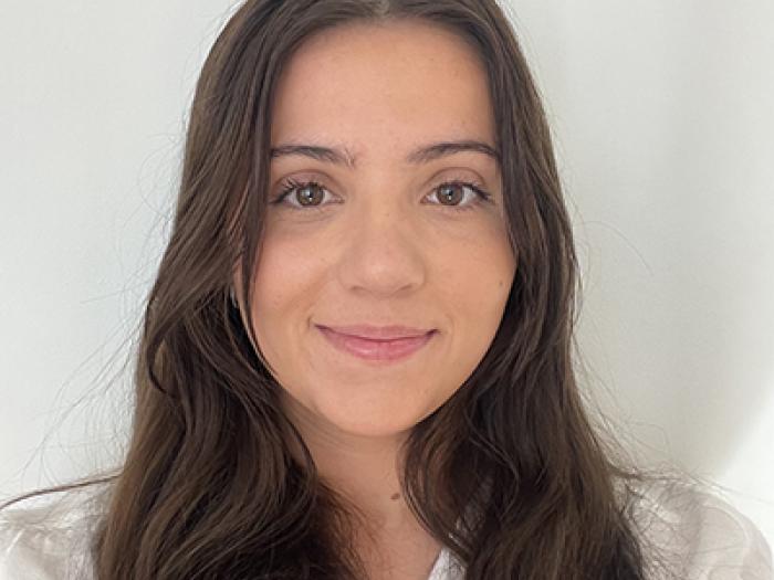 a woman with brown hair and a white shirt