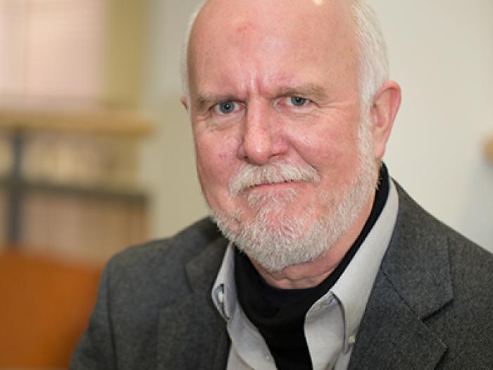 a man with a beard in a grey sport coat