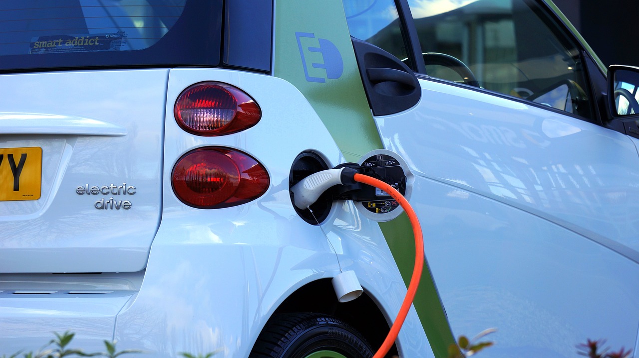 A white electric vehicle being charged
