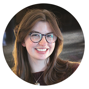 Emily Meltzer a woman with light brown hair and glasses and a gold necklace