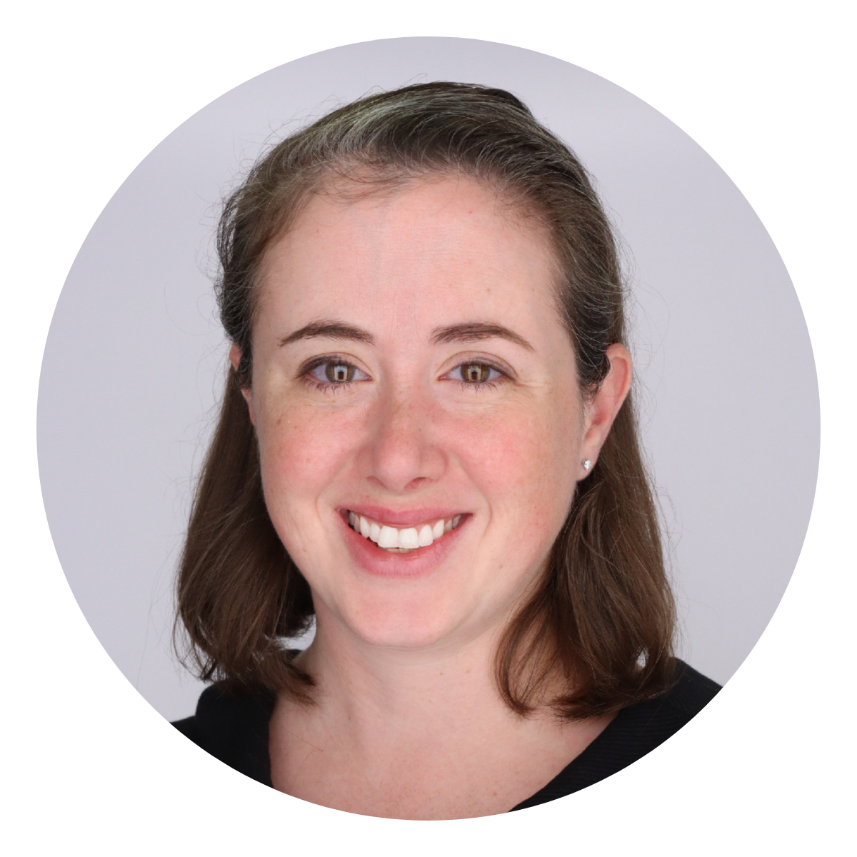 Caitlin Grady a woman with medium length brown hair smiling on a grey background