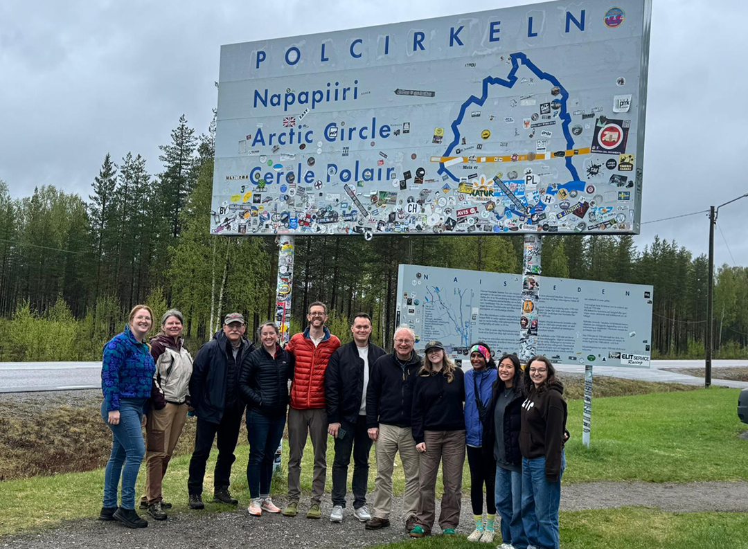 a group of researchers pose in front of a sign that reads, "Polcirkeln"