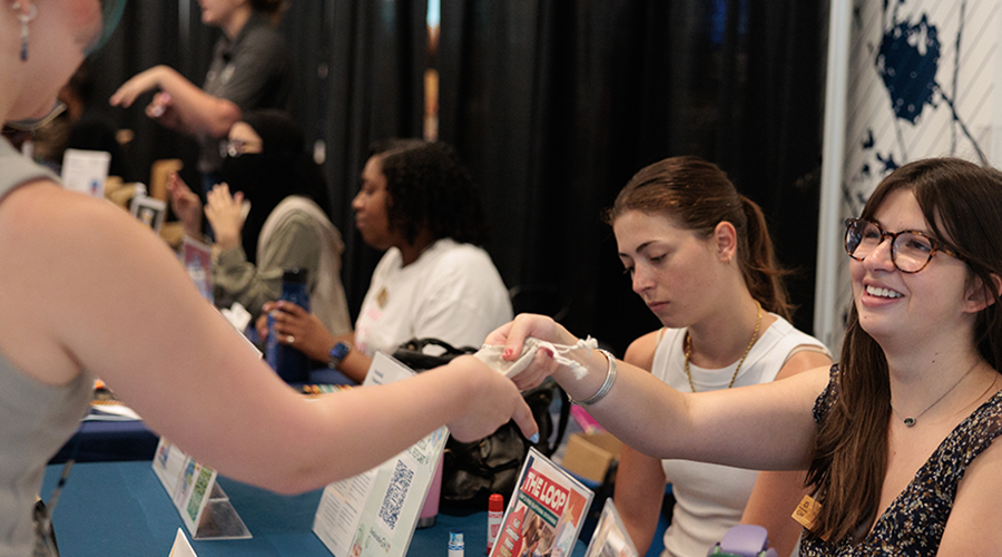 a student shares information at a tabling event