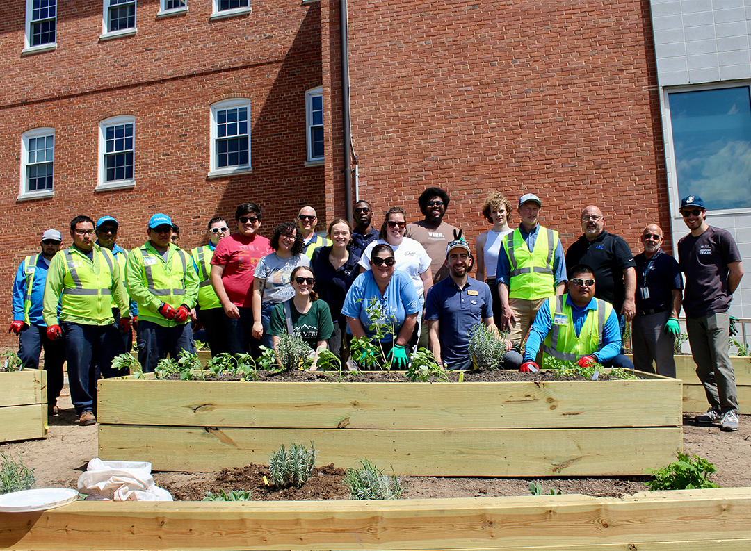 a large group pose behind a newly made raised garden bed