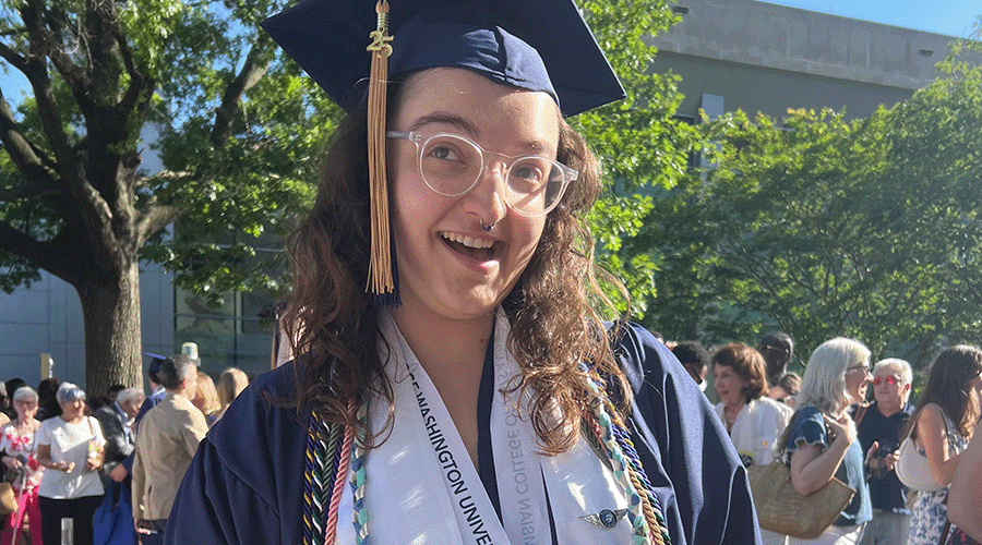 a graduating sustainability minor poses in regalia