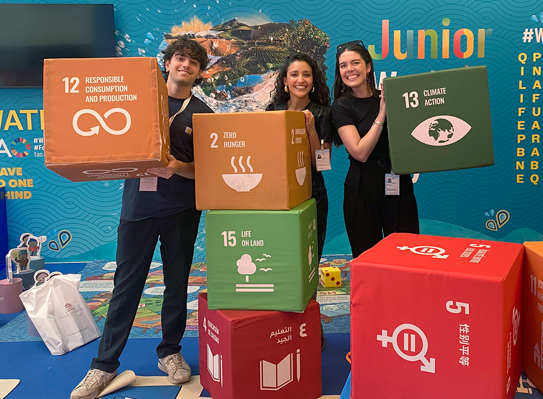 a group of three students hold orange and green cubes 