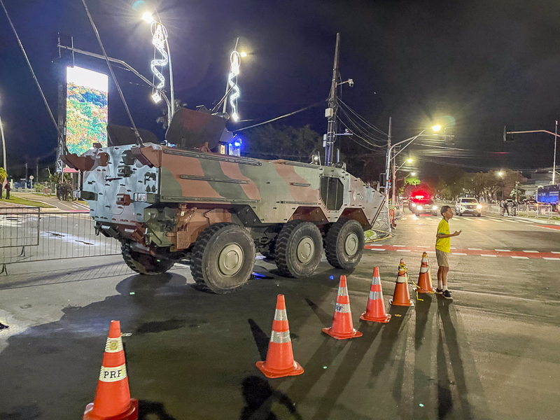 a military vehicle surrounded by orange cones on a street at night