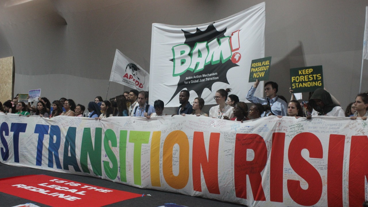 a banner held by a large group of people that says transition in rainbow colors 