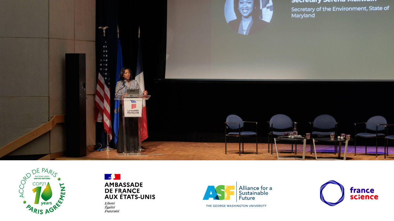 a woman in a silver coat on stage at a podium