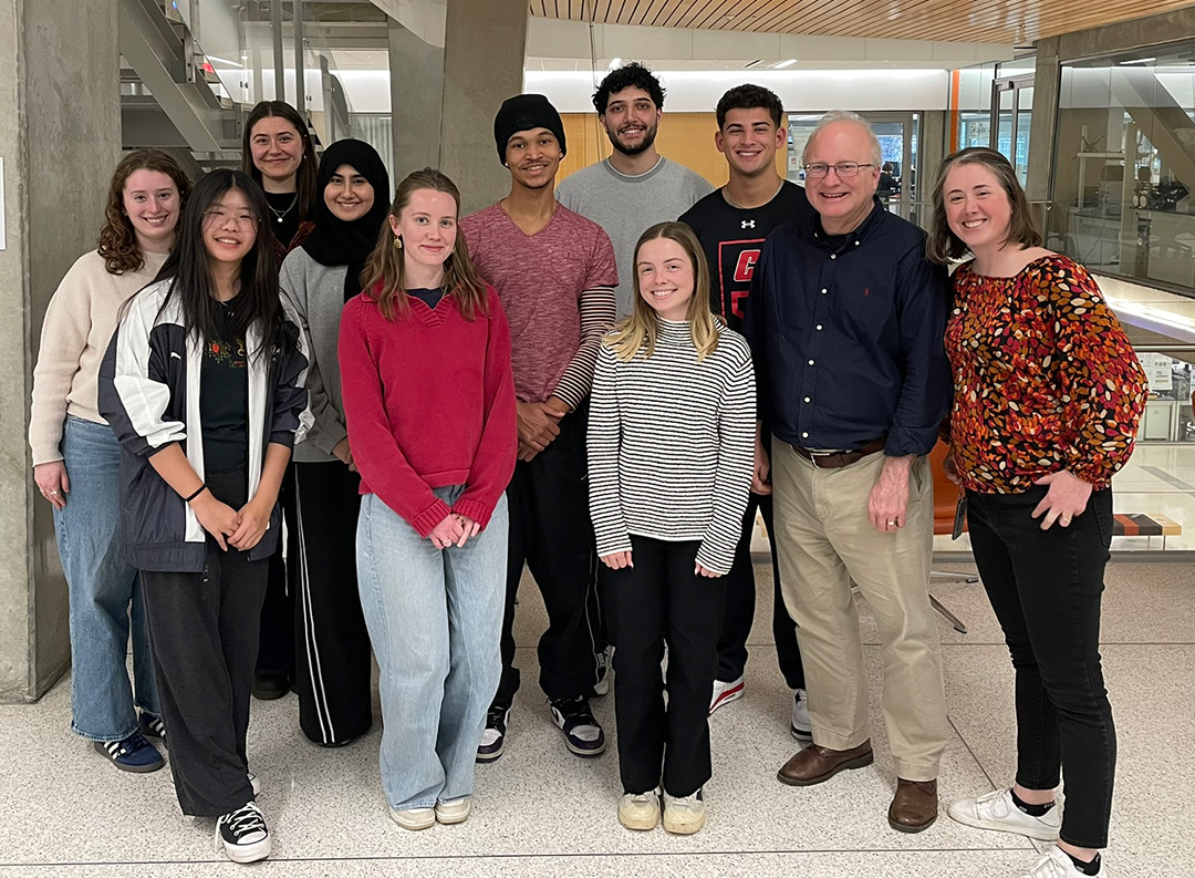 a group of 11 people stand near an elevator bay
