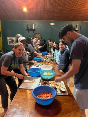 The GW Alternative Breaks cohort cutting vegetables and learning to cook with the local community. 
