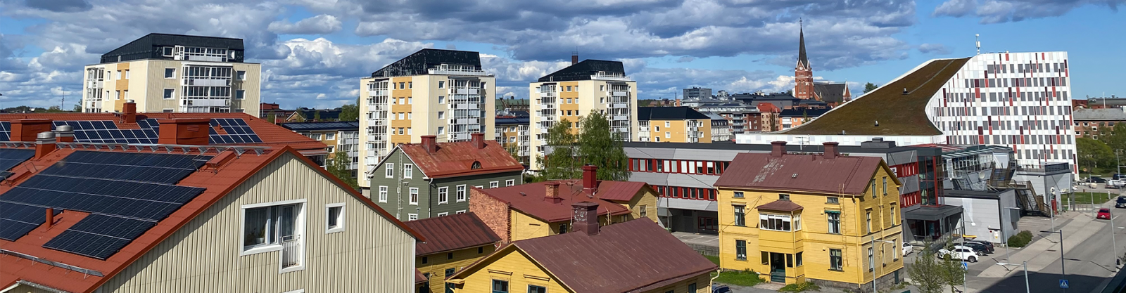 a cityscape of yellow and cream buildings under cloudy blue skies 