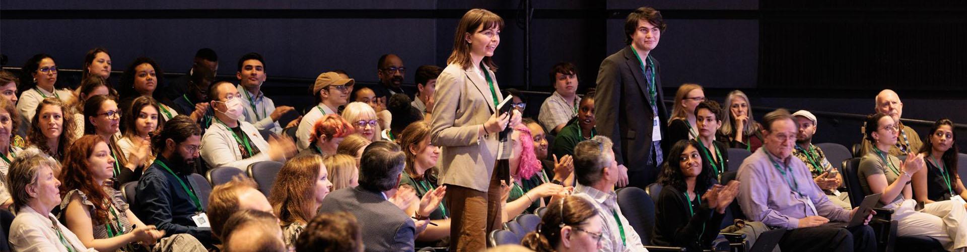 a person stands in a crowd with a microphone