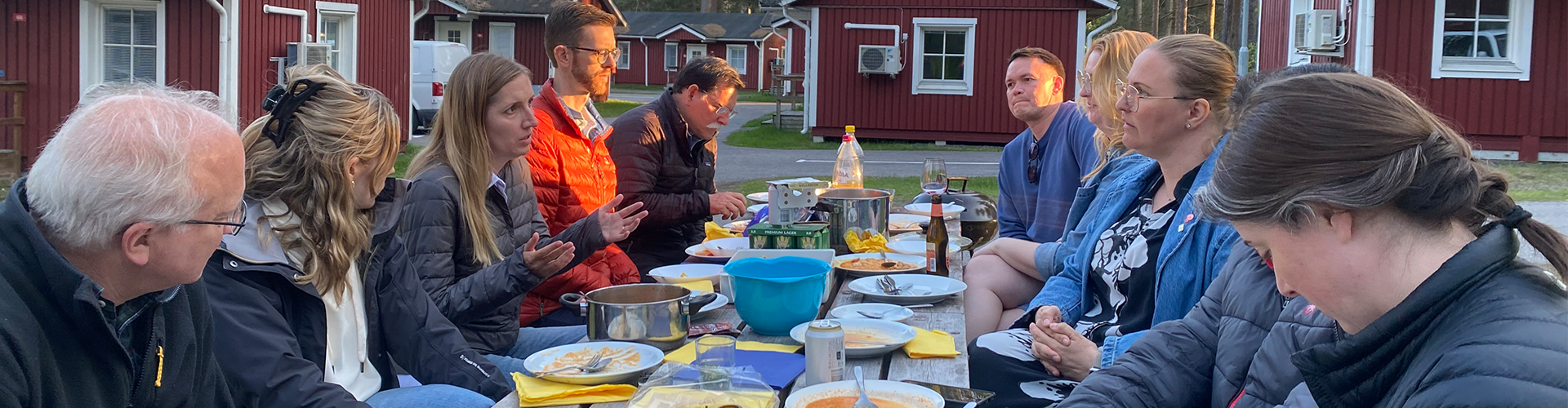SRI members gather at outdoor picnic tables and share a meal