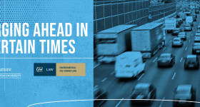 A blue background with cars on a highway and white text that reads Charging Ahead in Uncertain Times